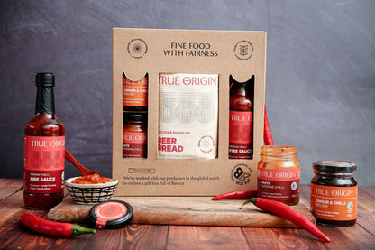 True Origin food products including sauces and a box on a wooden table with a dark background